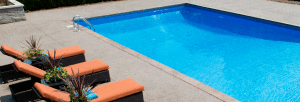 large rectangular pool with lawn chairs