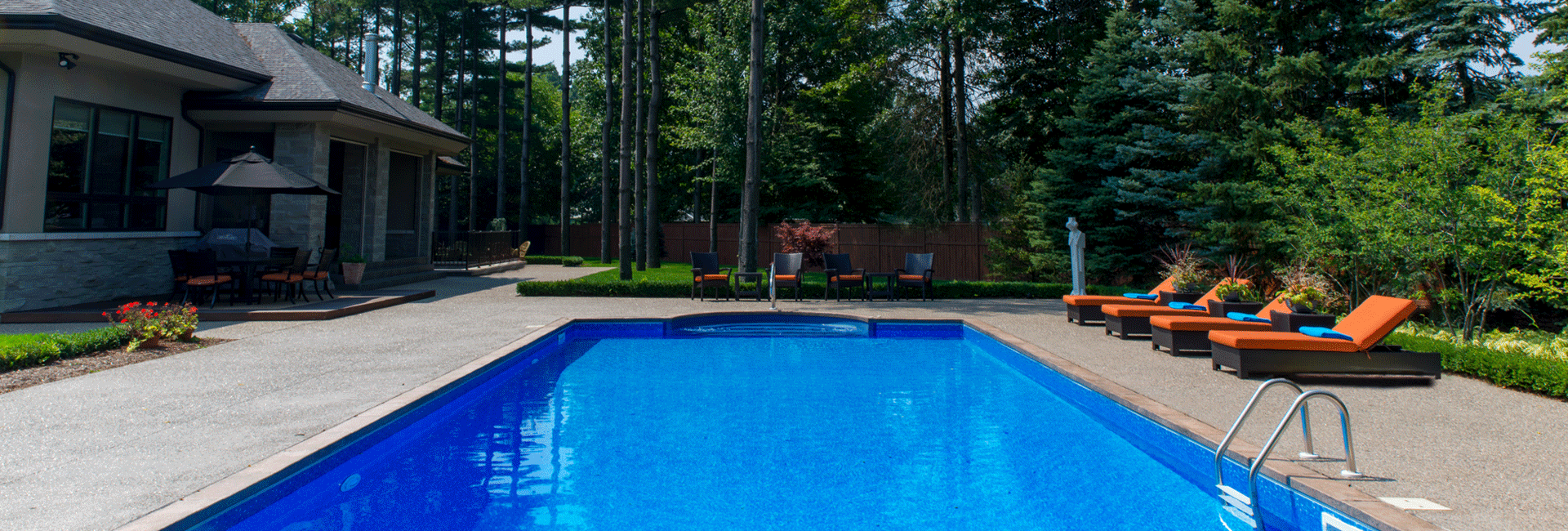 small rectangular pool with rock fence in background
